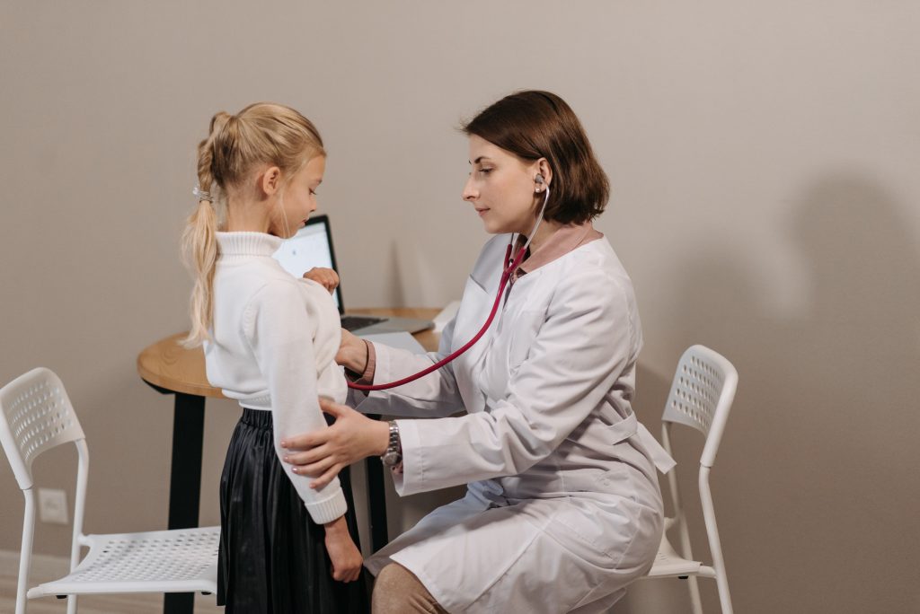 Kinderärztin bespricht Befunde mit einem Kind