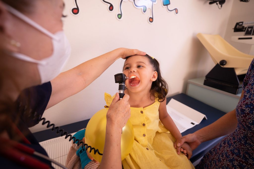 Kind hält das Stethoskop der Kinderärztin